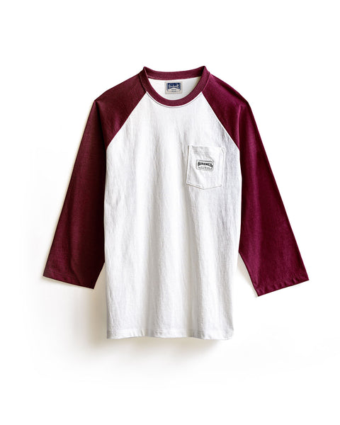 Introducing the Special Teez Pastime - Vintage White/Burgundy: a premium 3/4 sleeve raglan t-shirt made from soft USA-grown cotton, showcasing a vintage white body with burgundy three-quarter-length sleeves and a small chest pocket detailed with a rectangular patch of text. The shirt is shown against a white background.