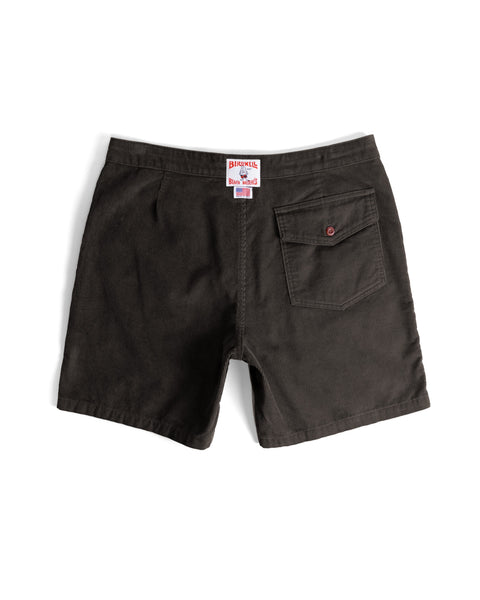 Back view of the Classic Corduroy Shorts - Brown, showcasing dark brown corduroy fabric, a single right back pocket with a button closure, a red patch label above the waistband, and an adjustable drawcord waist for a customizable fit.
