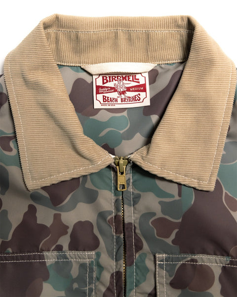 Close-up of a Capistrano Jacket - Frogskin/Acorn featuring a tan corduroy collar, zippered front, and a brand label on the inside neck.