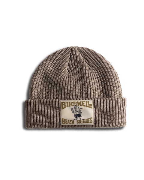 License Plate Watchcap - Walnut, a wide ribbed fisherman style beanie in brown featuring a rectangular patch with a cartoon character and the text Birdwell Beach Britches.