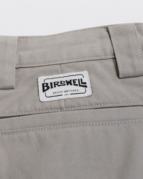 Close-up of beige Stockman Chino Shorts - Bone, featuring a rectangular Birdwell Beach Britches USA brand patch on the back waistband of these made in USA cotton twill shorts.
