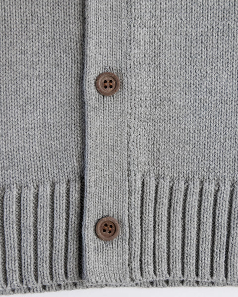 Close-up of the Racing Cardigan Sweater - Gray/Navy in a light grey cotton blend, featuring two brown buttons and a ribbed hem.