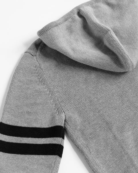 A close-up of the Comp Zip Sweater - Gray/Navy, a cotton-blend hoodie with two black horizontal stripes near the sleeve cuff, shown laid flat on a white surface.