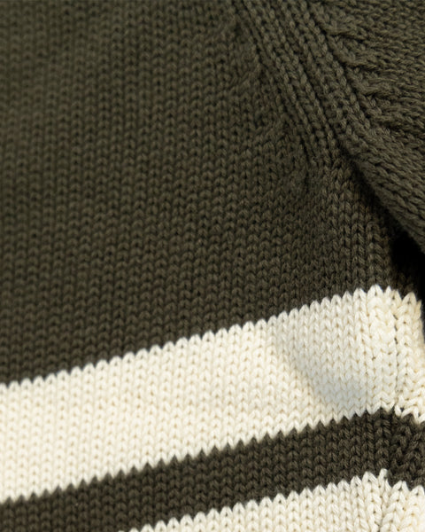 Close-up of the Comp Stripe Sweater - Dark Olive/Bone, featuring durable 100% cotton knit with two horizontal bone stripes. The detailed texture and individual stitches are clearly visible.