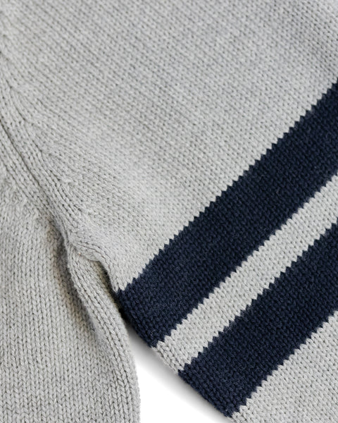Close-up of the Comp Stripe Sweater - Gray/Navy, featuring two parallel dark navy stripes on light gray fabric, laid flat against a white background.