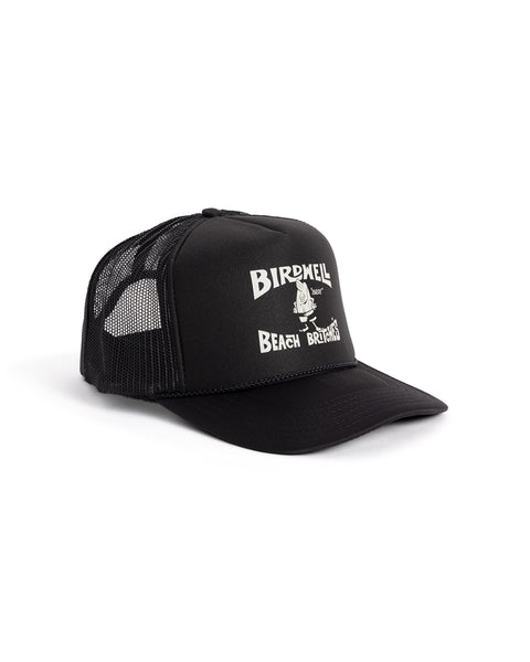 The License Plate Trucker - Black is a 5-panel foam trucker hat with BIRDHELL BEACH BREWING in white above a cartoon bird holding a beer, featuring a curved bill and mesh back for comfort.